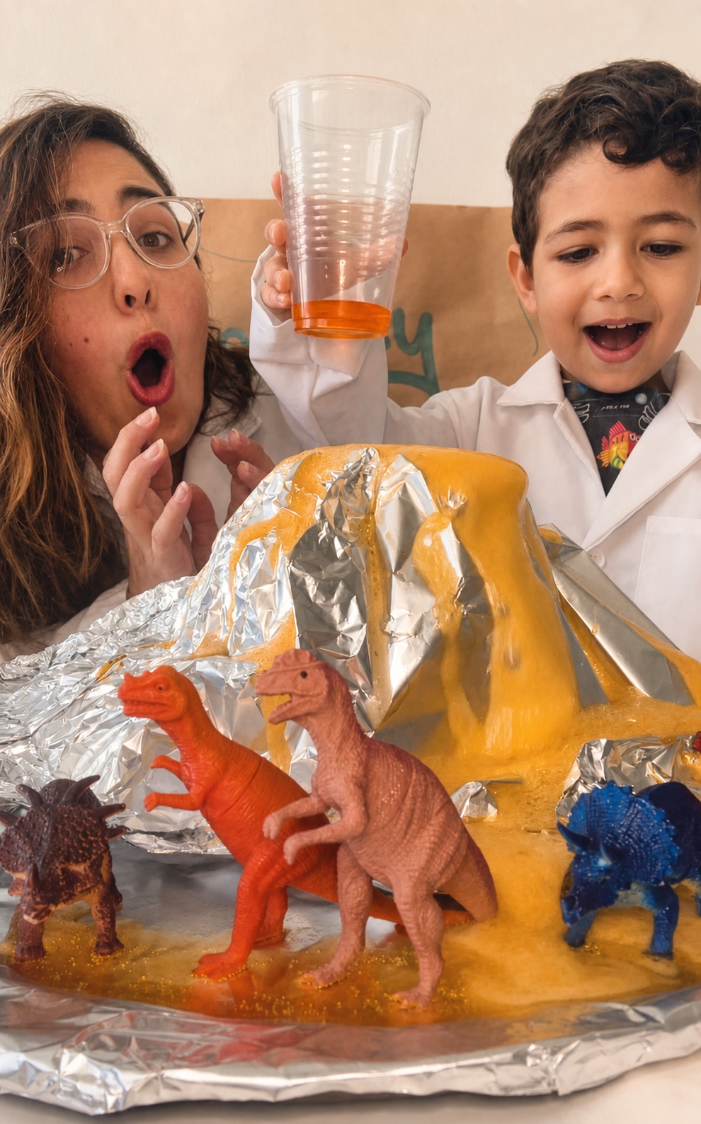 A mother and child reacting to a colorful dinosaur science experiment